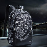Sac à dos garçon cm2 noir avec motifs blanc dessinés présenté sur fond urbain de nuit